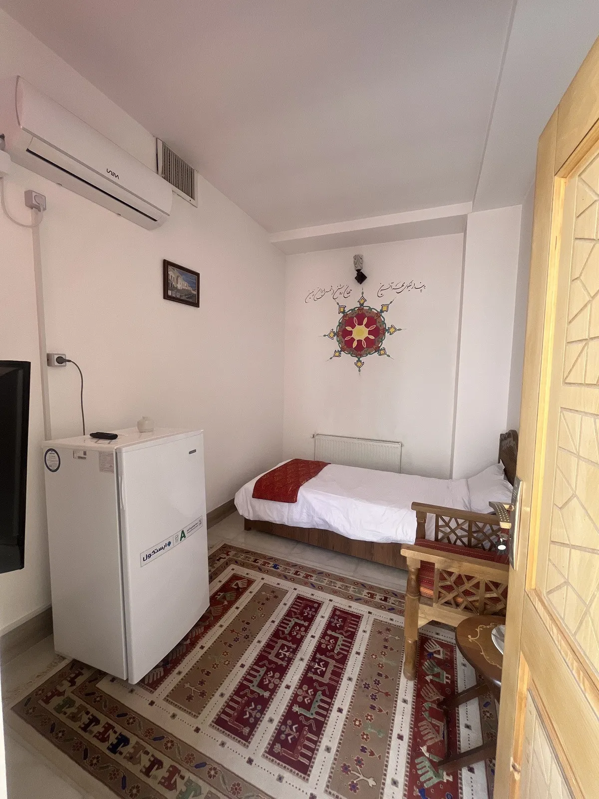اتاق عمارت حاکم با تخت یک‌نفره و فرش ایرانی