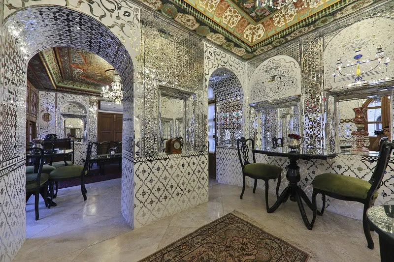 فضای داخلی عمارت سحرخیزان با آینهکاری و پنجرههای رنگی