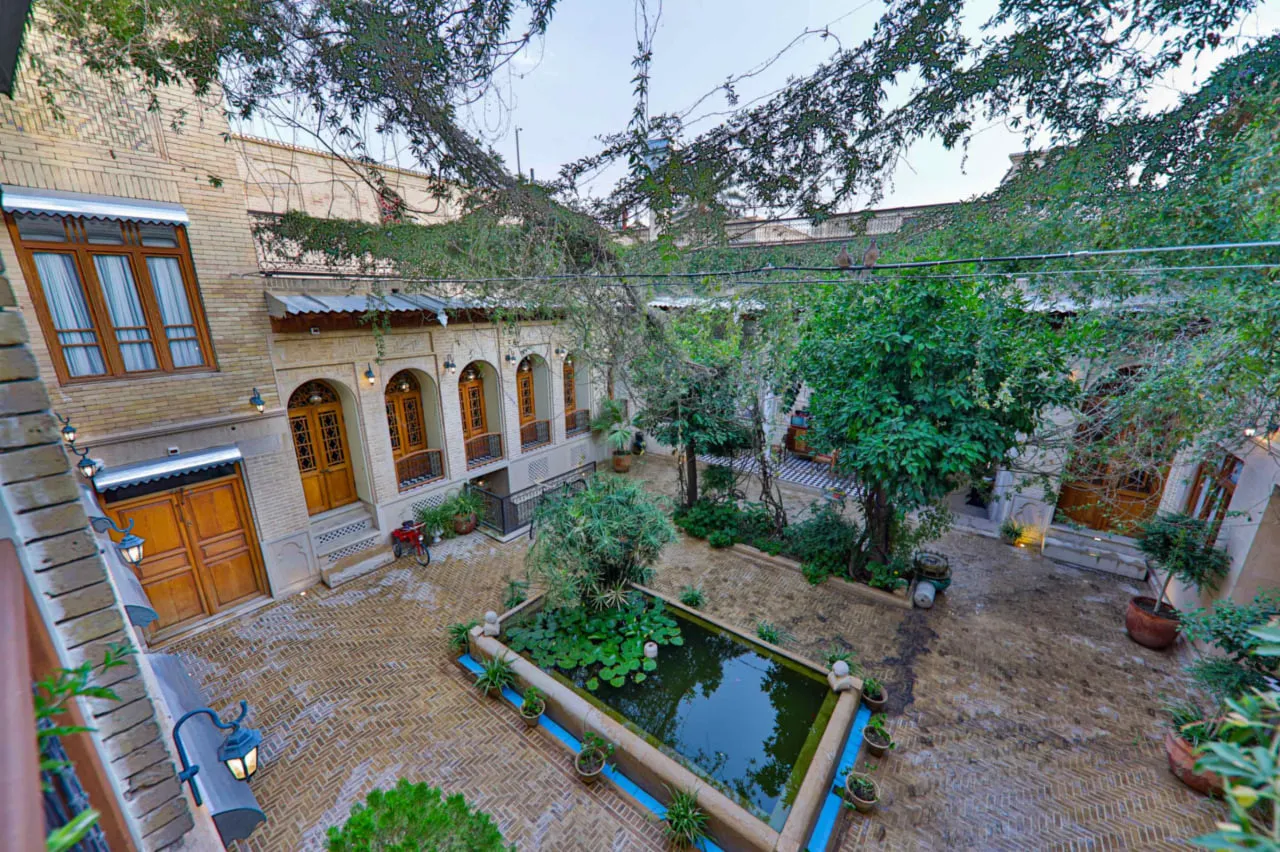 حیاط درخت‌کاری‌شده با حوض عمارت فرهادی