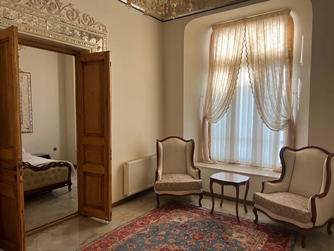 نشیمن هتل سرخاب با دو صندلی و پنجره پرده‌دار