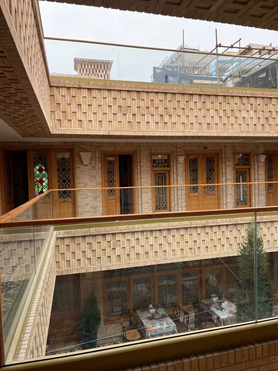 نمای حیاط داخلی ماه گیسو با ایوان و پنجره‌های رنگی