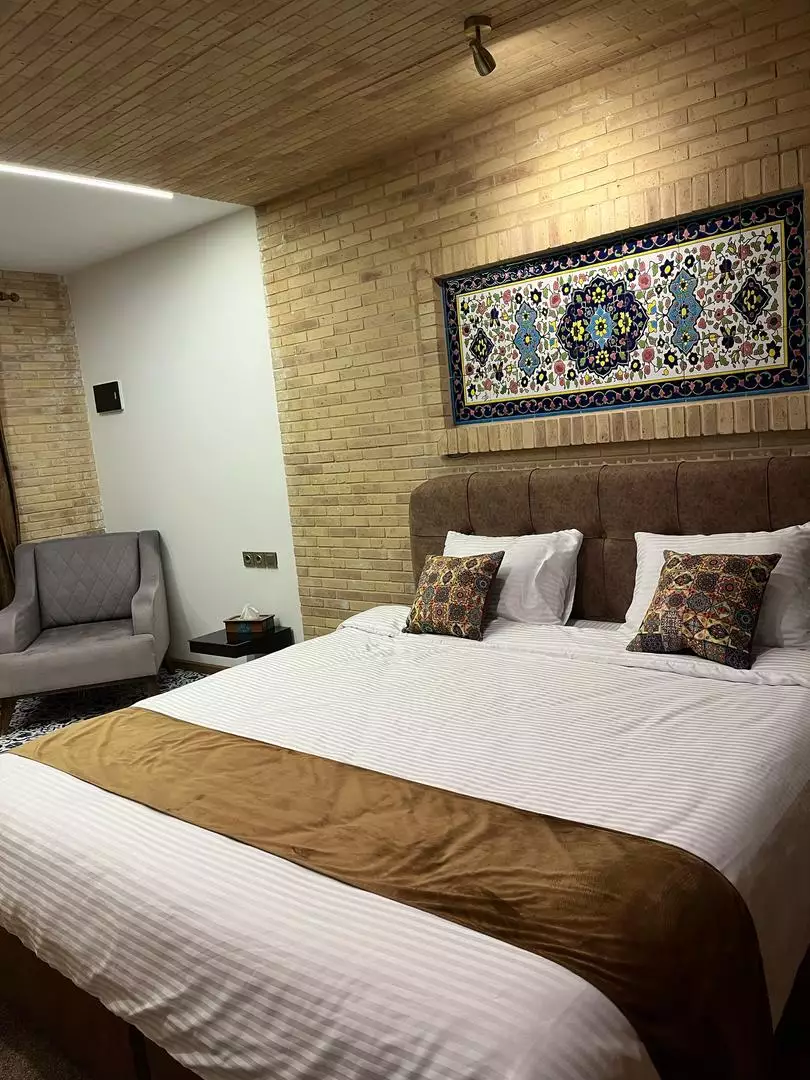 تخت دونفره با دیوارکوب قالی در هتل ماه گیسو