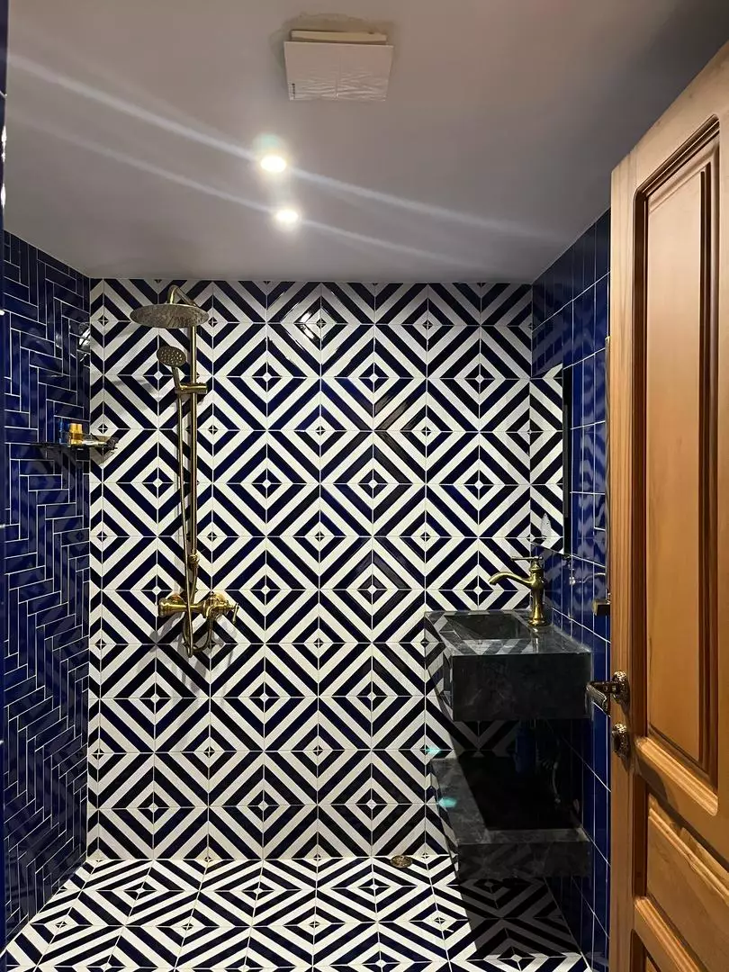 حمام با کاشی‌های هندسی سیاه‌وسفید هتل ماه گیسو
