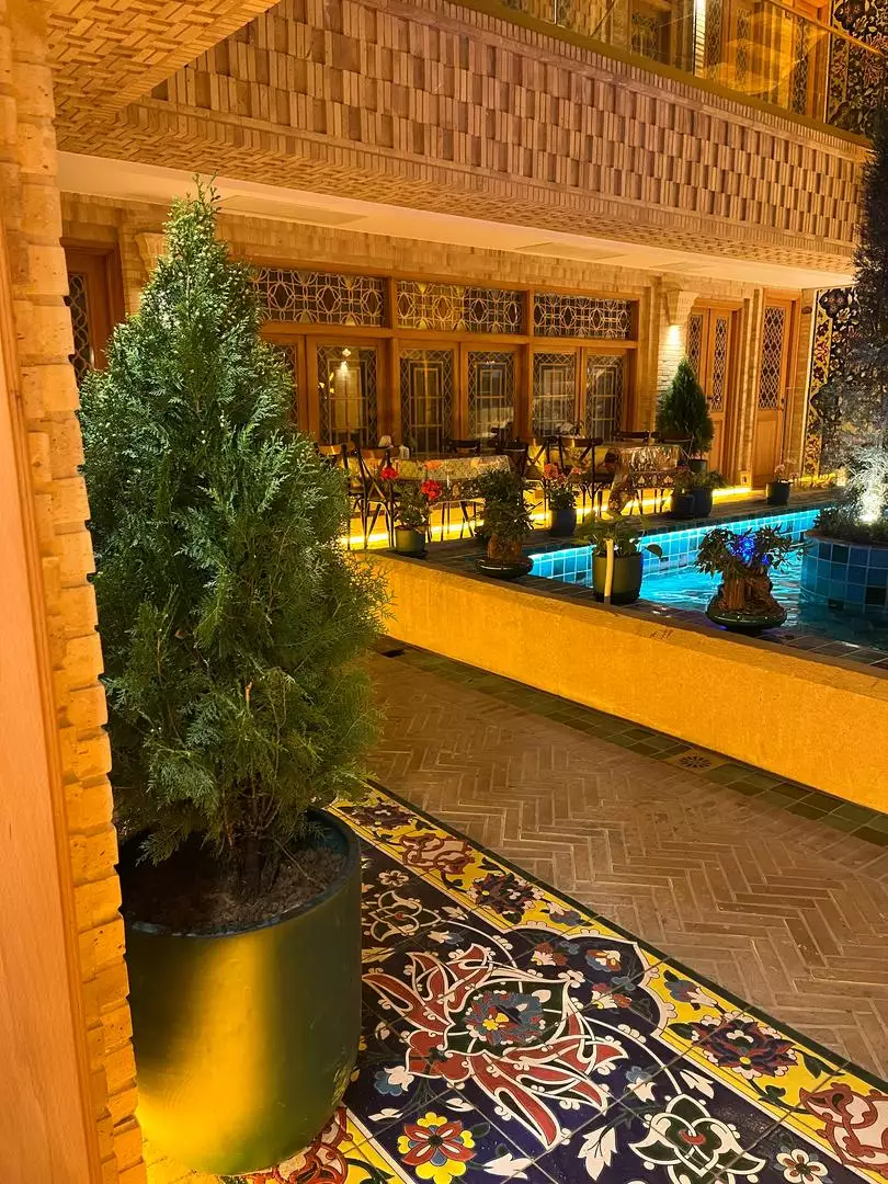حیاط هتل ماه گیسو با حوض و گلدان درختچه