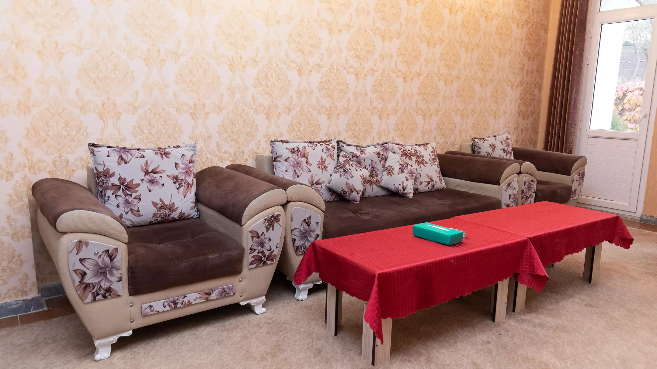 مبلمان گل‌دار و میز قرمز در نشیمن هتل ارشاد