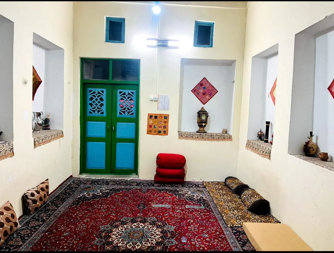 فضای نشیمن سنتی با فرش قرمز در سرای کربلایی فریدون