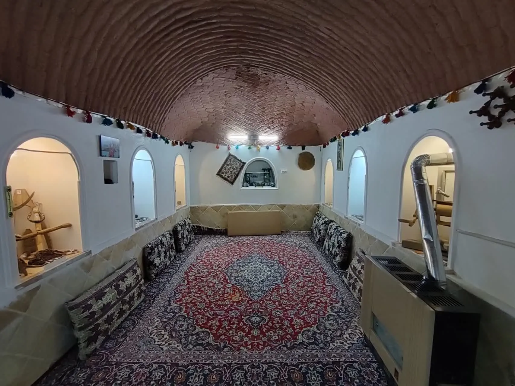 اتاق سنتی سرای کربلایی فریدون با سقف آجری و فرش ایرانی
