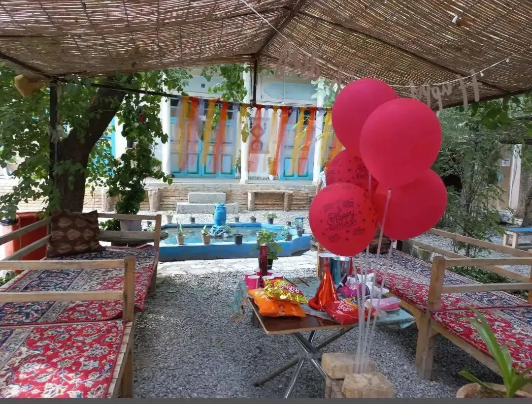 فضای نشیمن سرای کربلایی فریدون با بادکنک‌های قرمز