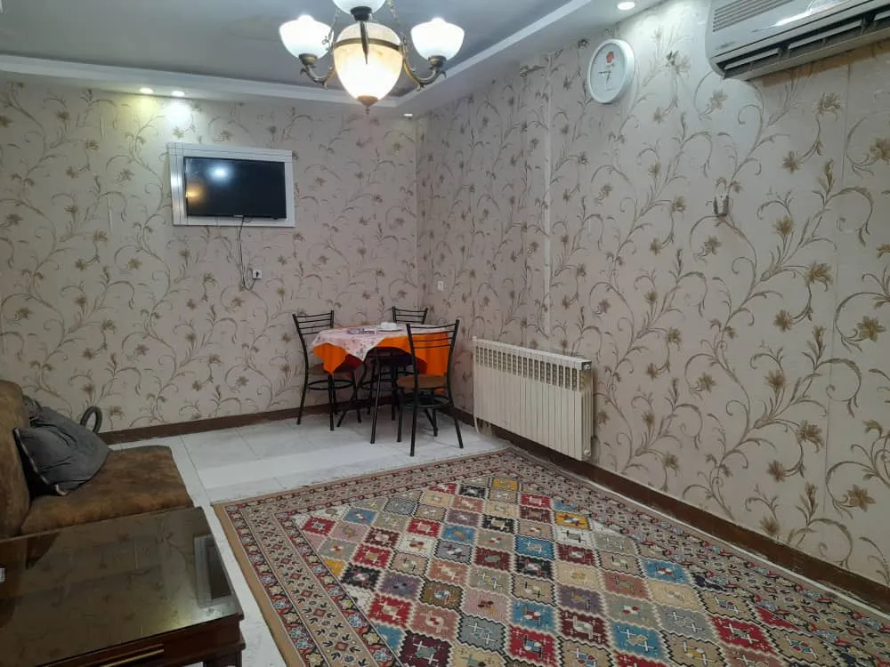 فضای نشیمن هتل آتبین با فرش و میز غذاخوری