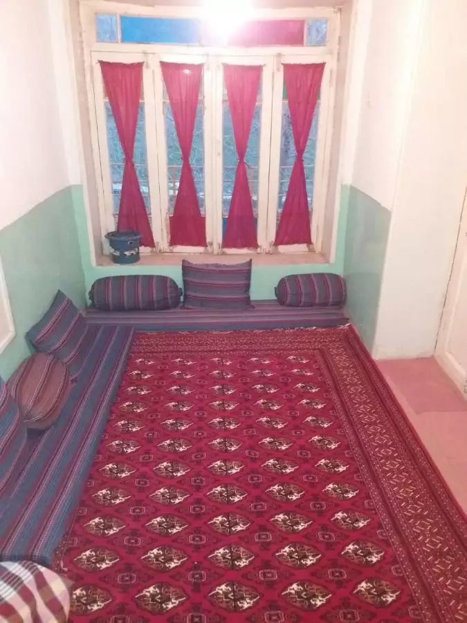 اتاق چشمه سبز با فرش قرمز و نشیمن دور پنجره