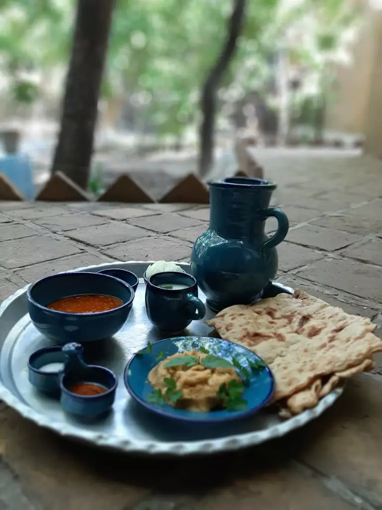 صبحانه با نان محلی و ظرفهای سفالی در چشمه سبز