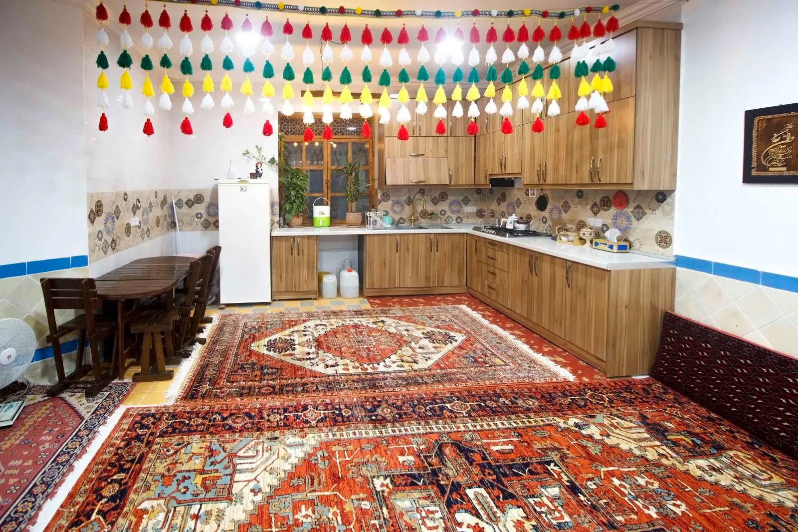 آشپزخانه سرای امیر بیک با کابینت چوبی و فرش ایرانی