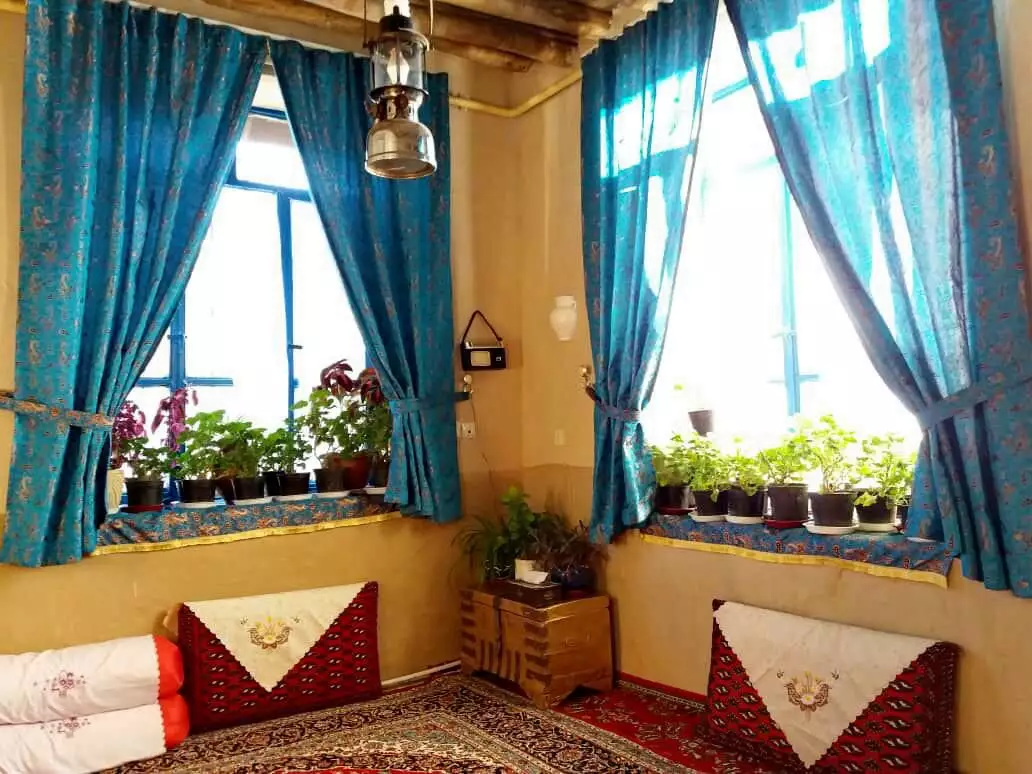 نشیمن سنتی ترلان کنار پنجره‌های فیروزه‌ای