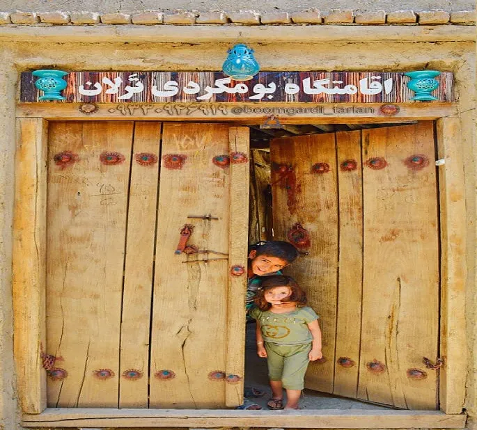در چوبی اقامتگاه ترلان با دو کودک
