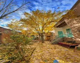حیاط پاییزی خانه جواهری بوئین میاندشت با درخت زرد