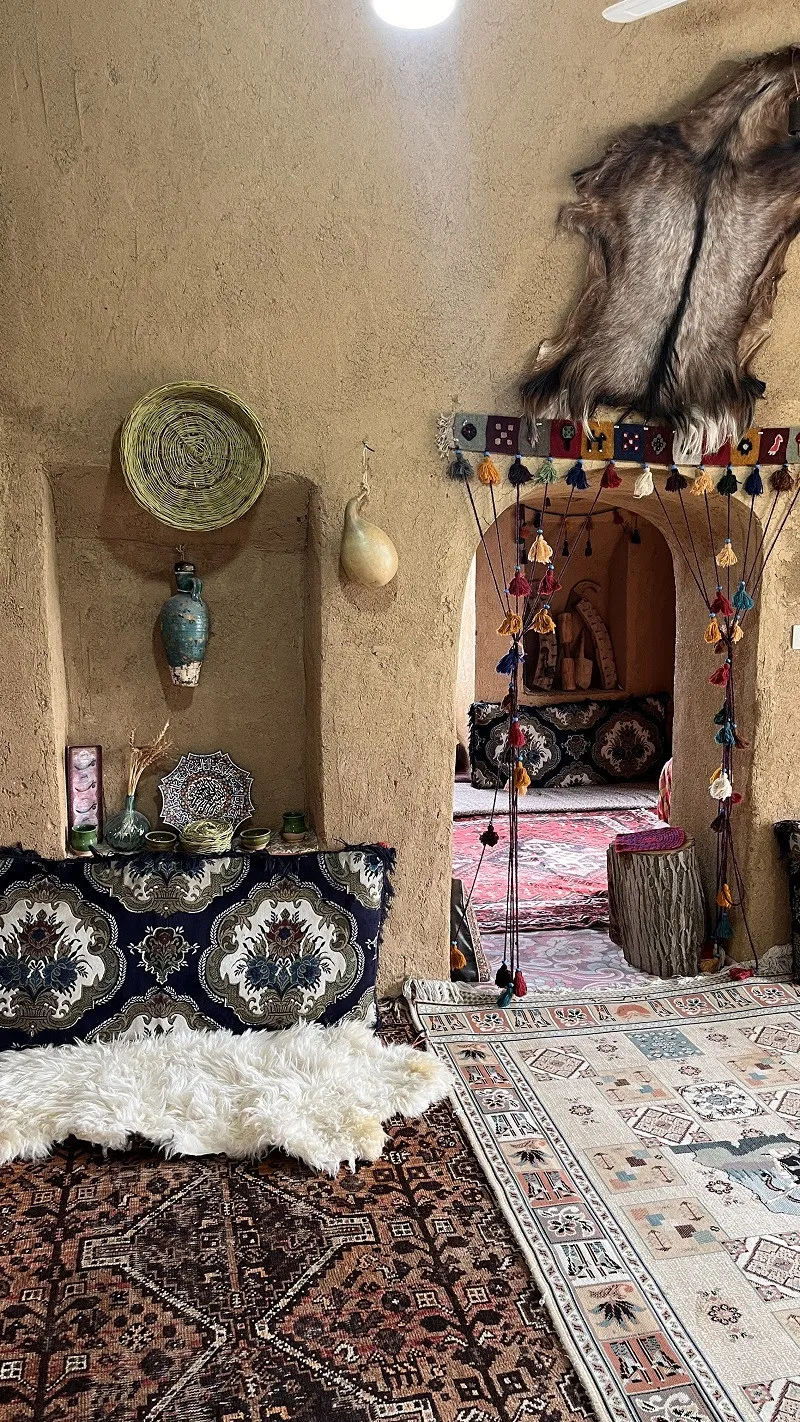 فضای داخلی سنتی علی کدخدا با طاقچه و فرش‌های ایرانی