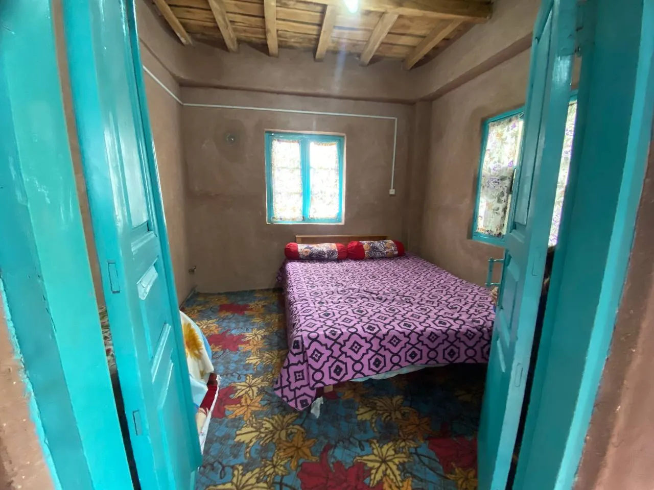 اتاق خواب حاج علی با تخت دونفره و درهای فیروزه‌ای