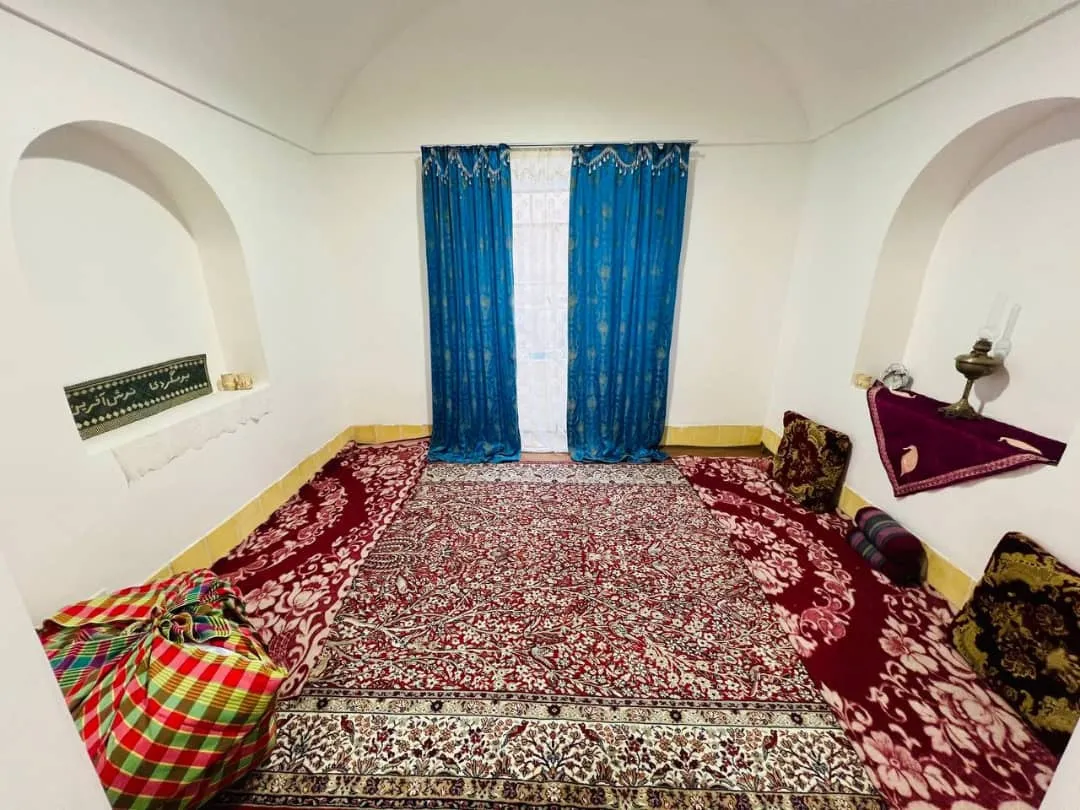 اتاق سنتی هتل نوش آفرین با فرش و پرده آبی