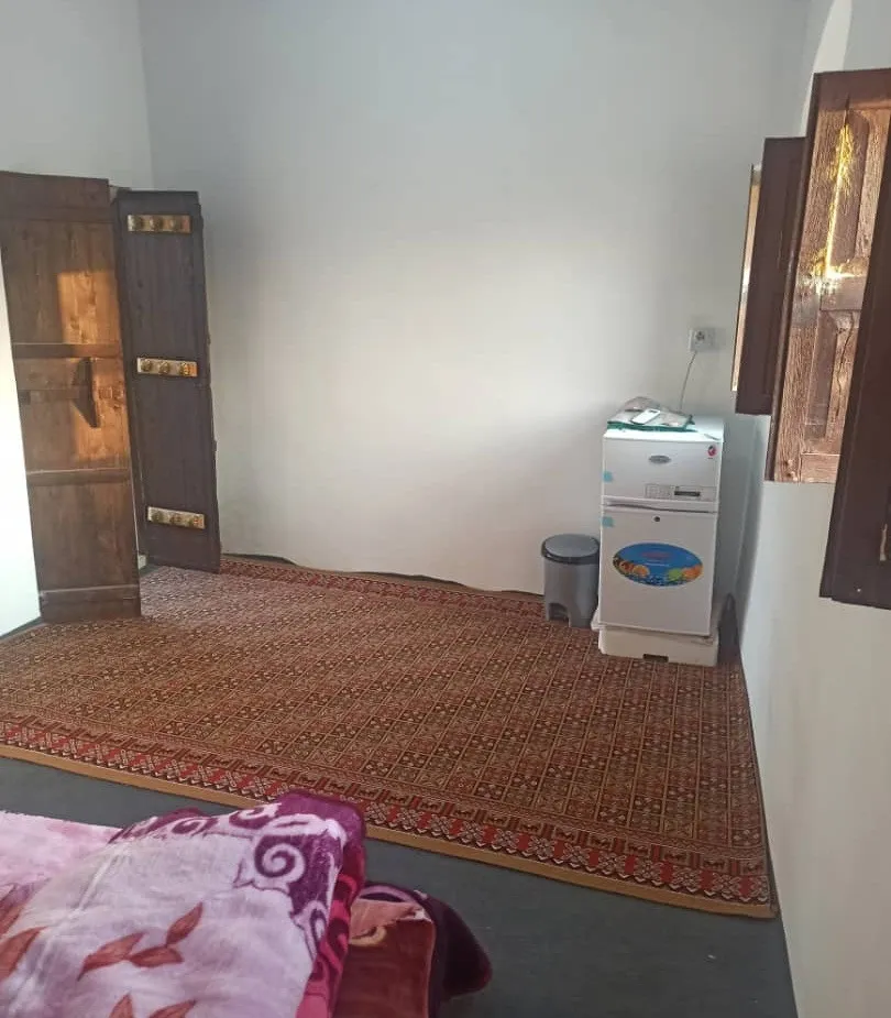 اتاق اقامتگاه چیرا با فرش سنتی و یخچال