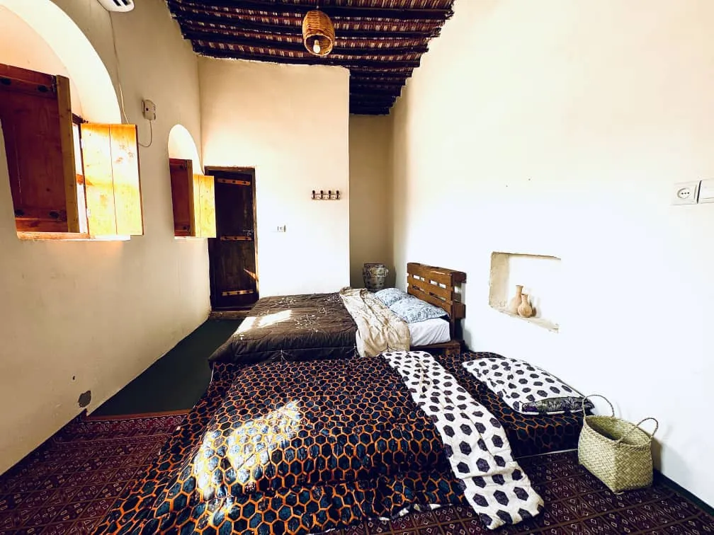 دو تخت با روتختی طرح‌دار در اقامتگاه چیرا