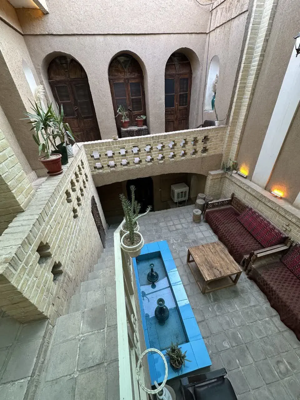 حیاط خانه سمنانی‌ها با حوض آبی و تخت سنتی