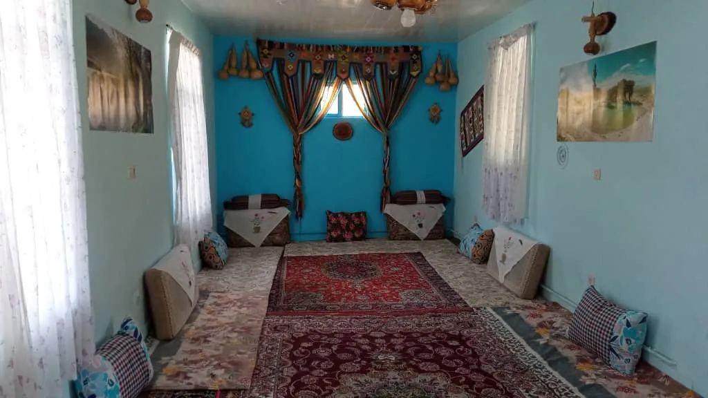 اتاق نشیمن سنتی هتل آنیل با فرش و پشتیهای رنگارنگ