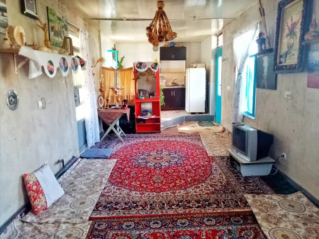 فضای نشیمن سنتی با قالی قرمز در آنیل