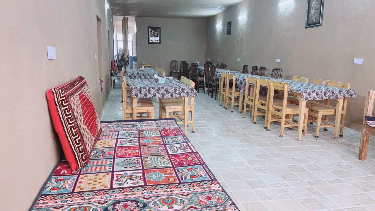 فضای غذاخوری سنتی هتل درویش با فرش و میزهای چوبی