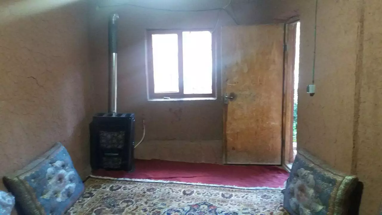 اتاق کاهگلی با بخاری و فرش اقامتگاه حاج محمد