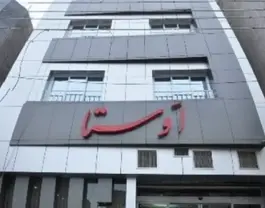 نمای بیرونی ساختمان هتل اوستا با تابلوی قرمز