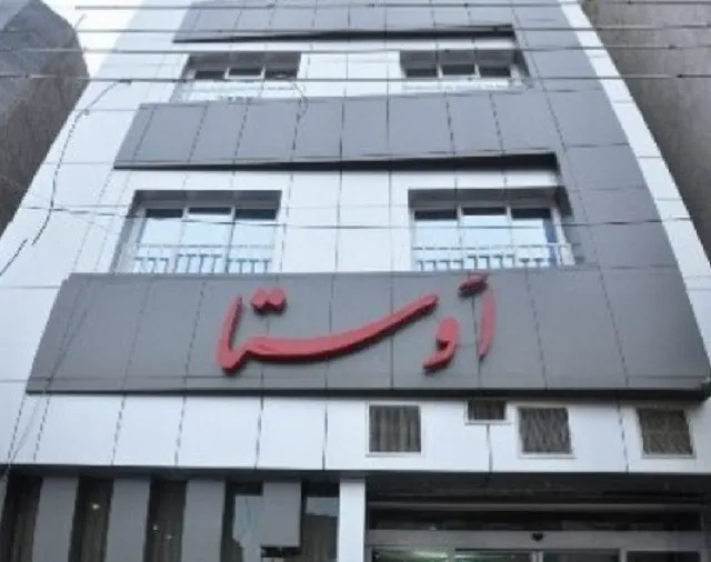 نمای بیرونی ساختمان هتل اوستا با تابلوی قرمز