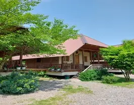 کلبه چوبی گیلک ده میان درختان و باغچه