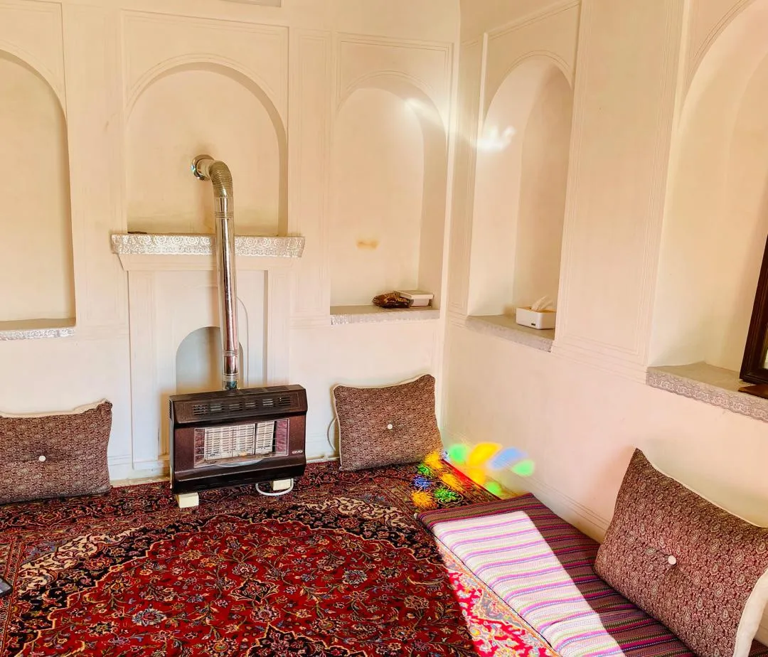 اتاق سنتی عمارت طاهری با بخاری و فرش ایرانی