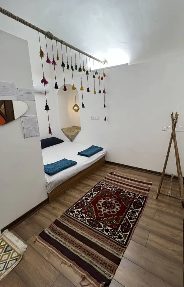 تخت اتاق با قالیچه سنتی در کاج کهن