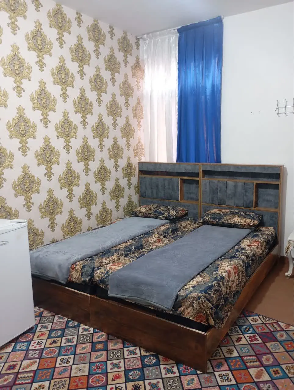 تخت دونفره با پرده آبی در هتل دلیار