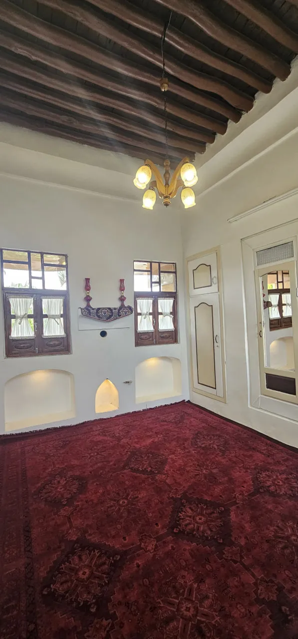 اتاق عمارت پریزاد با سقف تیرچوبی و فرش
