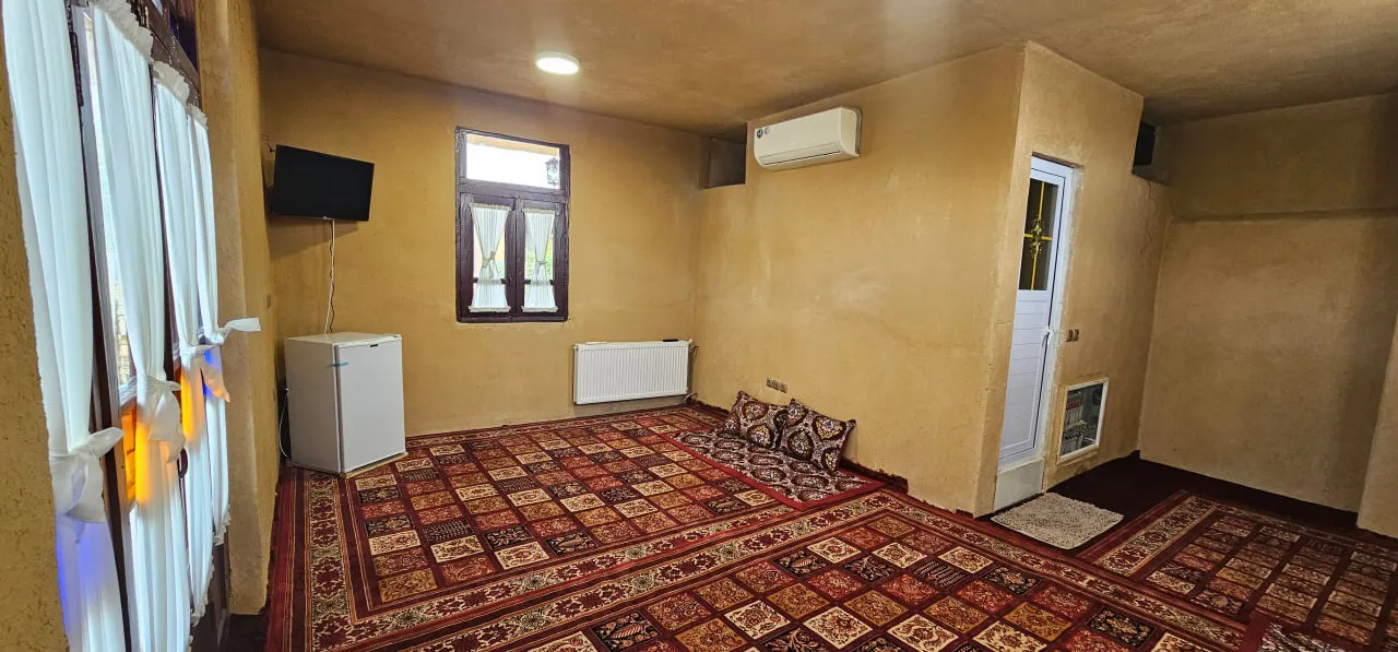 اتاق عمارت پریزاد با فرش قرمز و پنجره بلند