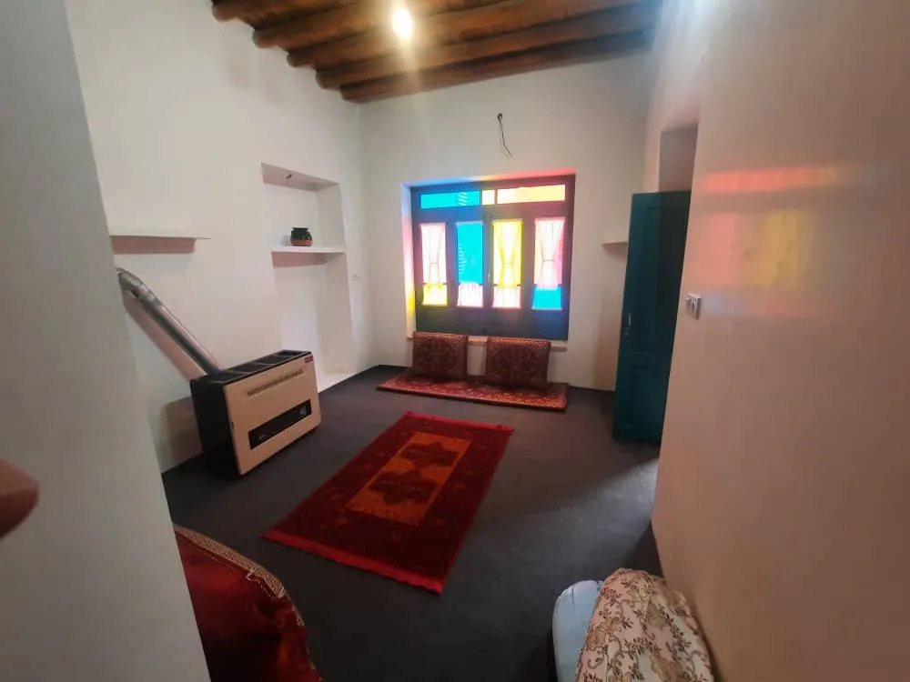 اتاق کاشانه با پنجره رنگی و فرش