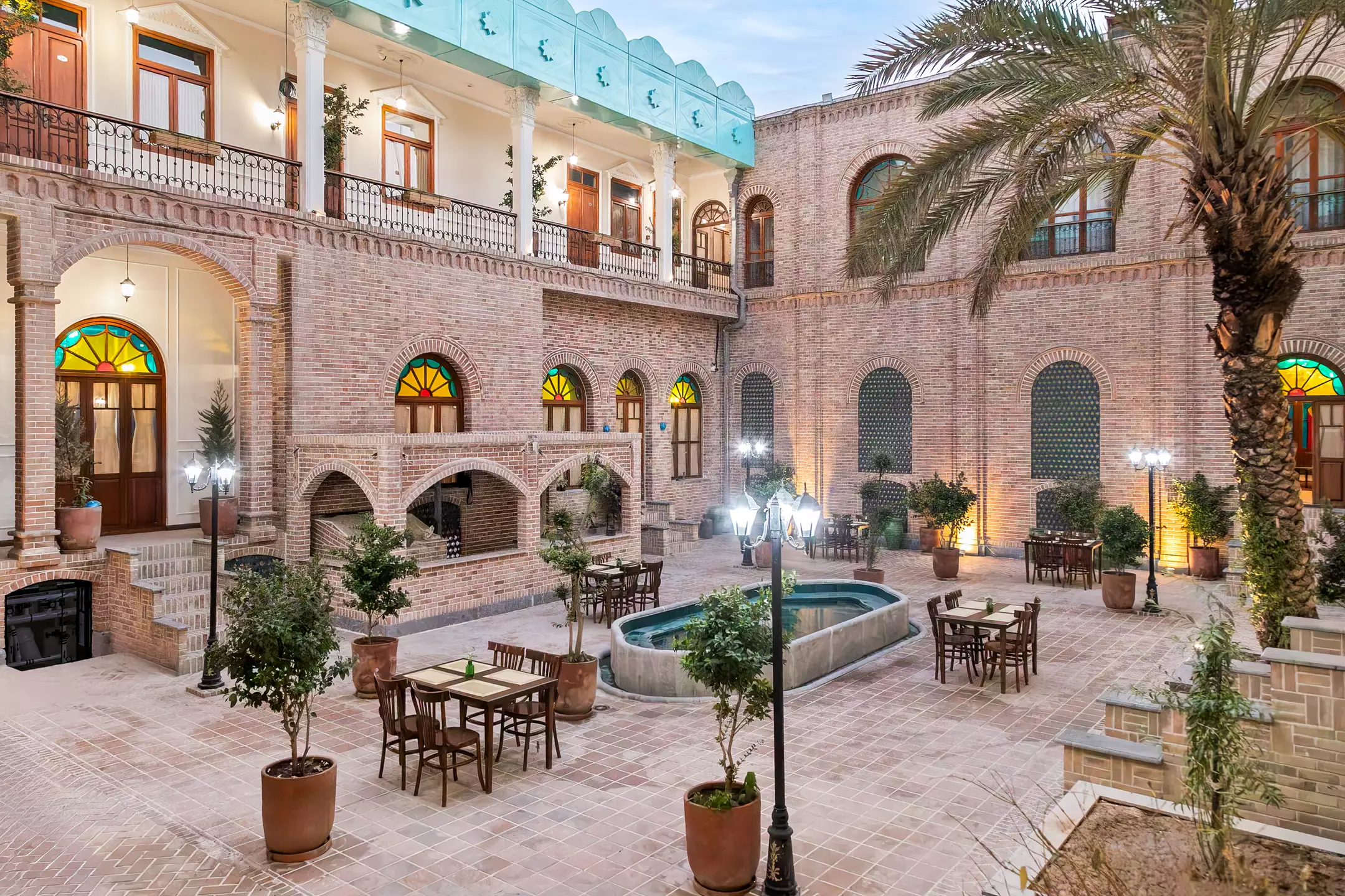 حیاط آجری عمارت ملوکانه با حوض و نخل