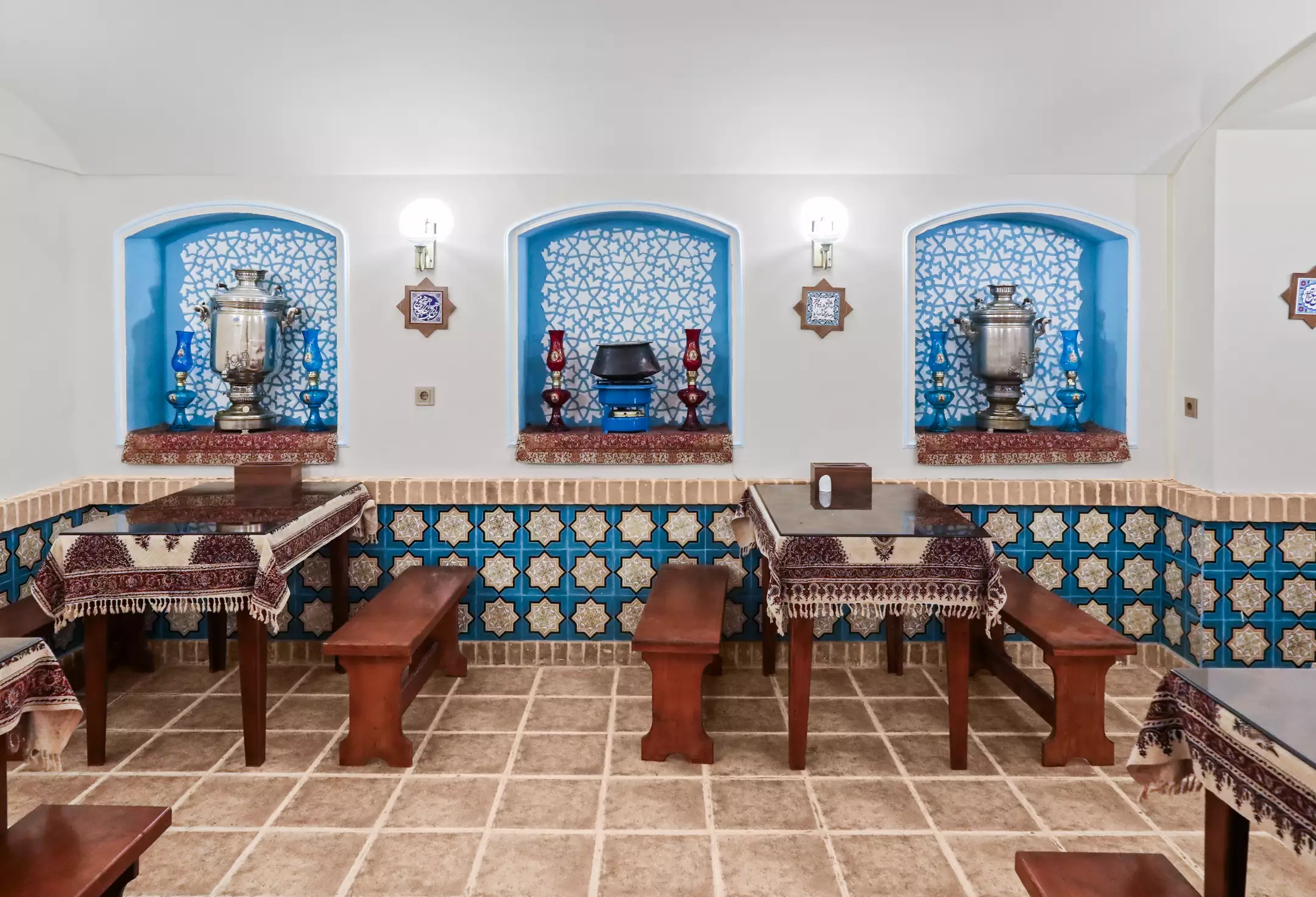 فضای سنتی چای‌خوری با سماورهای تزئینی در عمارت ملوکانه