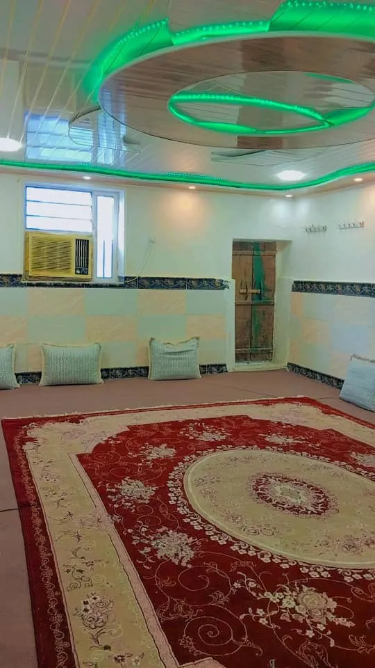 سالن نشیمن هتل ناخدا علی با فرش قرمز و چراغ سقفی سبز
