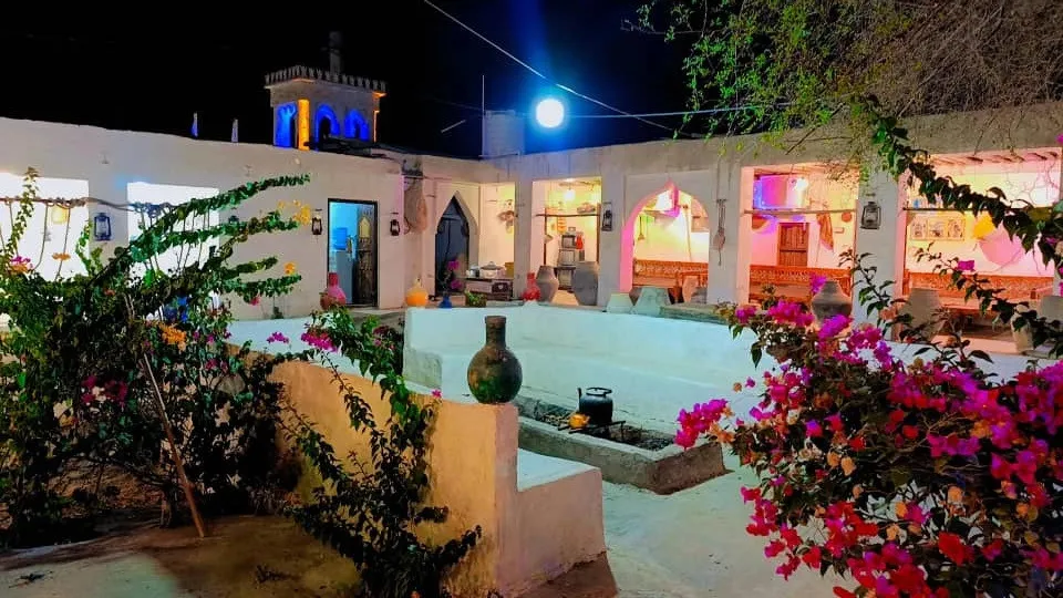 حیاط و گل‌های رنگارنگ اقامتگاه ناخدا علی در شب