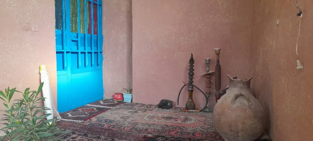 ورودی هه وارگه ی هانیس با در آبی و کوزه سفالی
