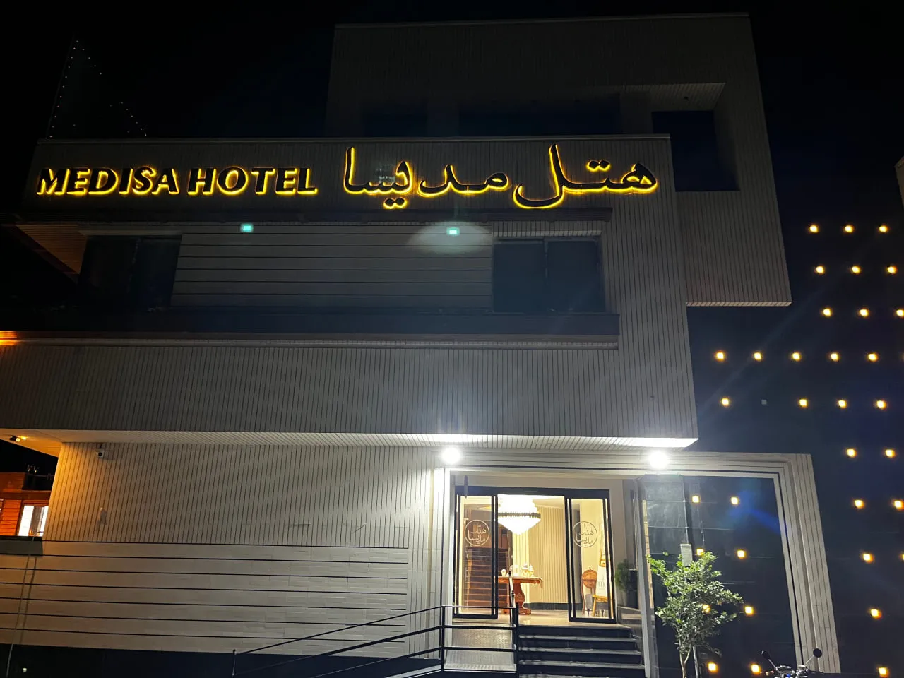 ورودی هتل مدیسا با تابلوی نورانی شبانه