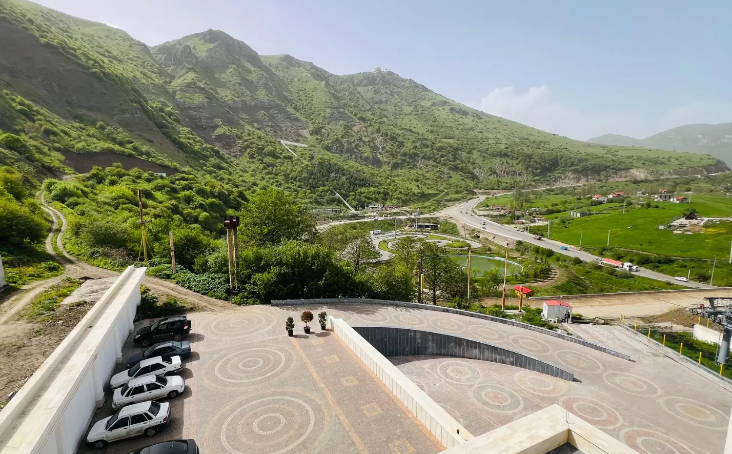 نمای کوهستان سرسبز و پارکینگ هتل حیران