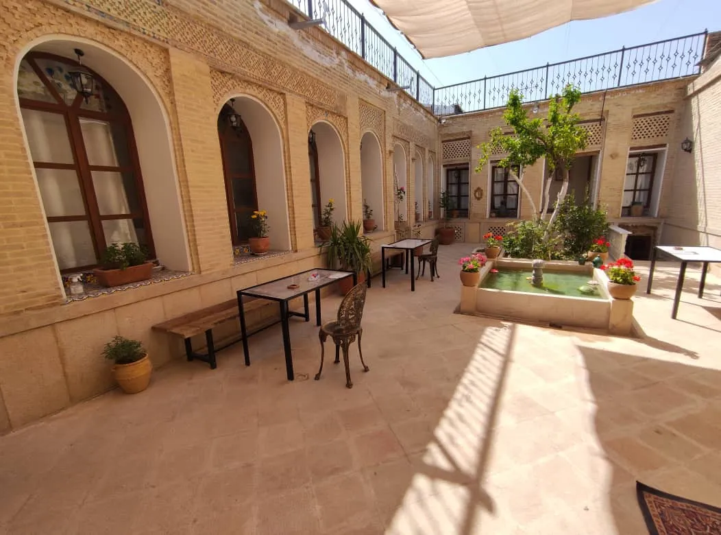 حیاط سنتی اقامتگاه صوفی راز با حوض و گلدان