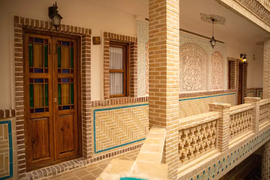 ایوان آجری هتل دیاوا با درهای چوبی و کاشی‌کاری