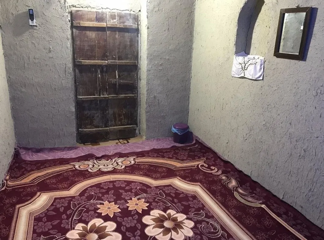 اتاق کاکا با فرش گل‌دار و در چوبی