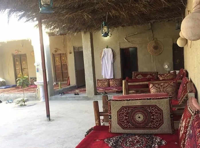 فضای نشیمن سنتی با فرش و پشتی در هتل کاکا