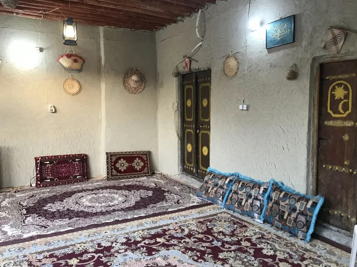 اتاق نشیمن سنتی اقامتگاه کاکا با فرش و پشتی